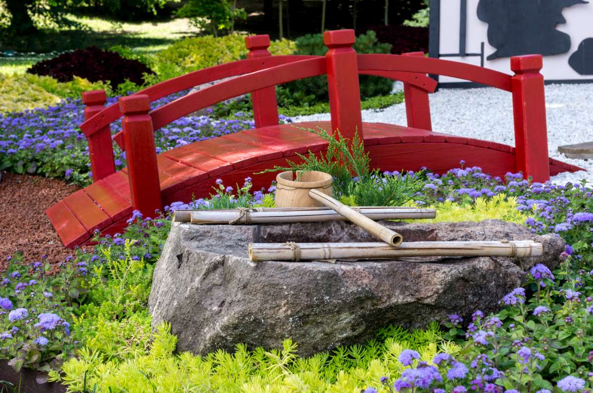 červený drevený mostík v japonskej záhrade